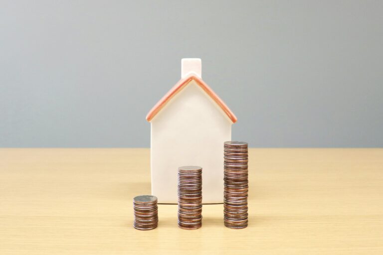 Maison miniature et pièces de monnaie représentant un plex à vendre dans la Vallée-du-Richelieu