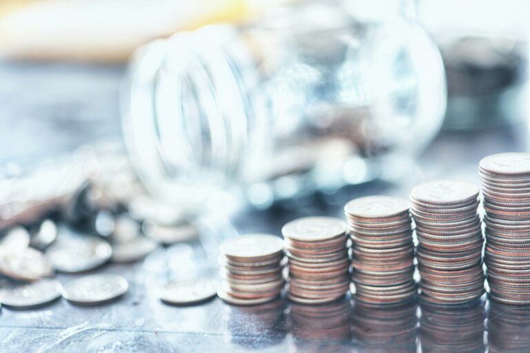 Pile de pièces et calcul financier pour le financement d’un achat immobilier en 2026